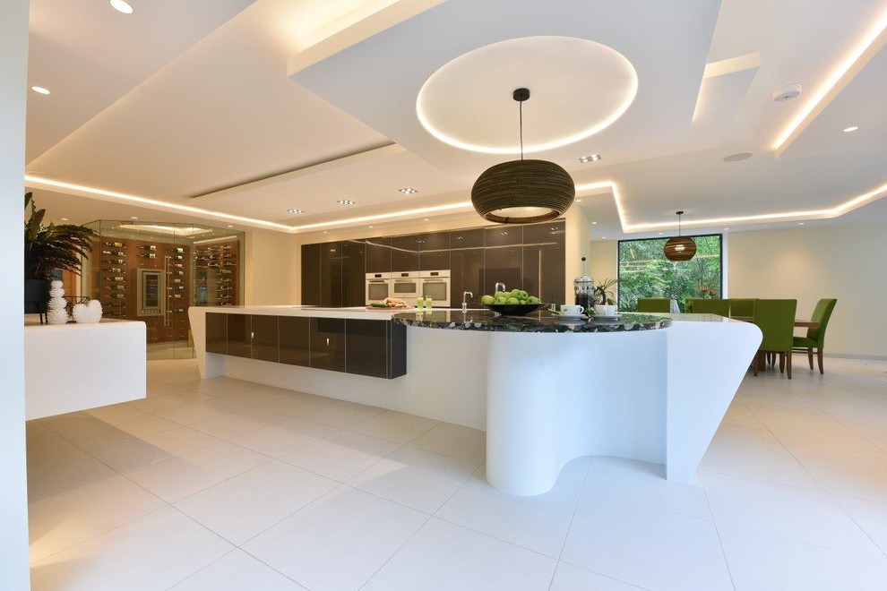 Photo of an expansive modern kitchen in Manchester with an integrated sink, glass-front cabinets, grey cabinets, solid surface benchtops, white appliances, porcelain floors, with island, white floor and white benchtop.