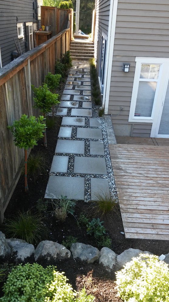 This is an example of a traditional side yard garden in Seattle with concrete pavers.