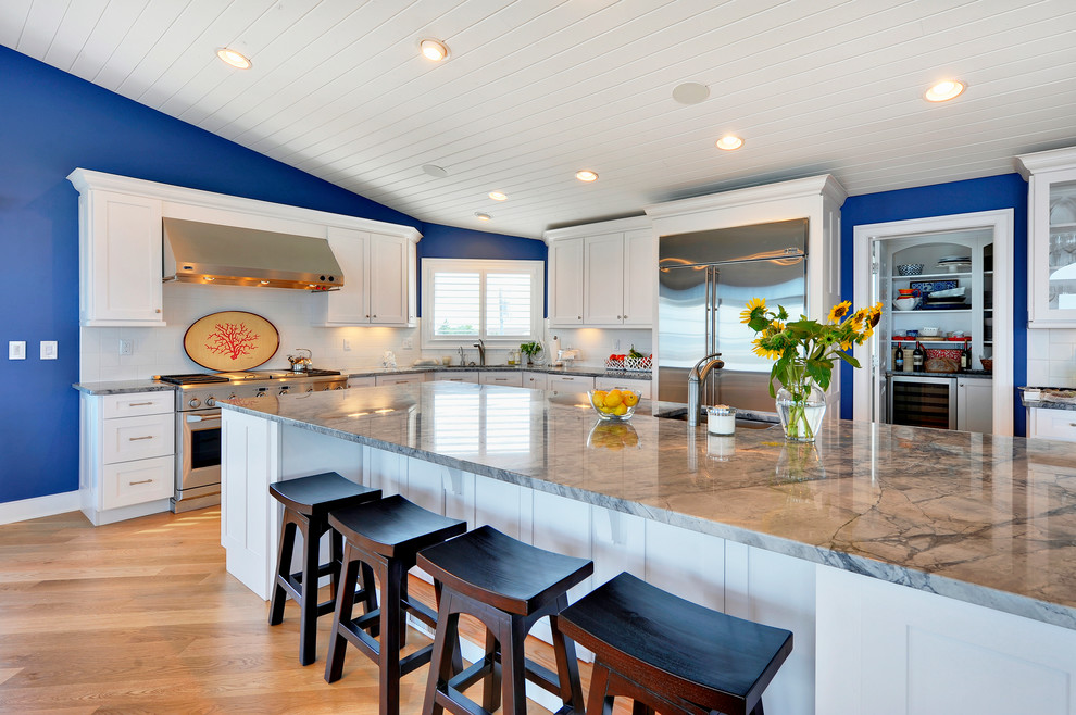Example of a transitional kitchen design in Philadelphia with shaker cabinets, white cabinets, white backsplash and stainless steel appliances