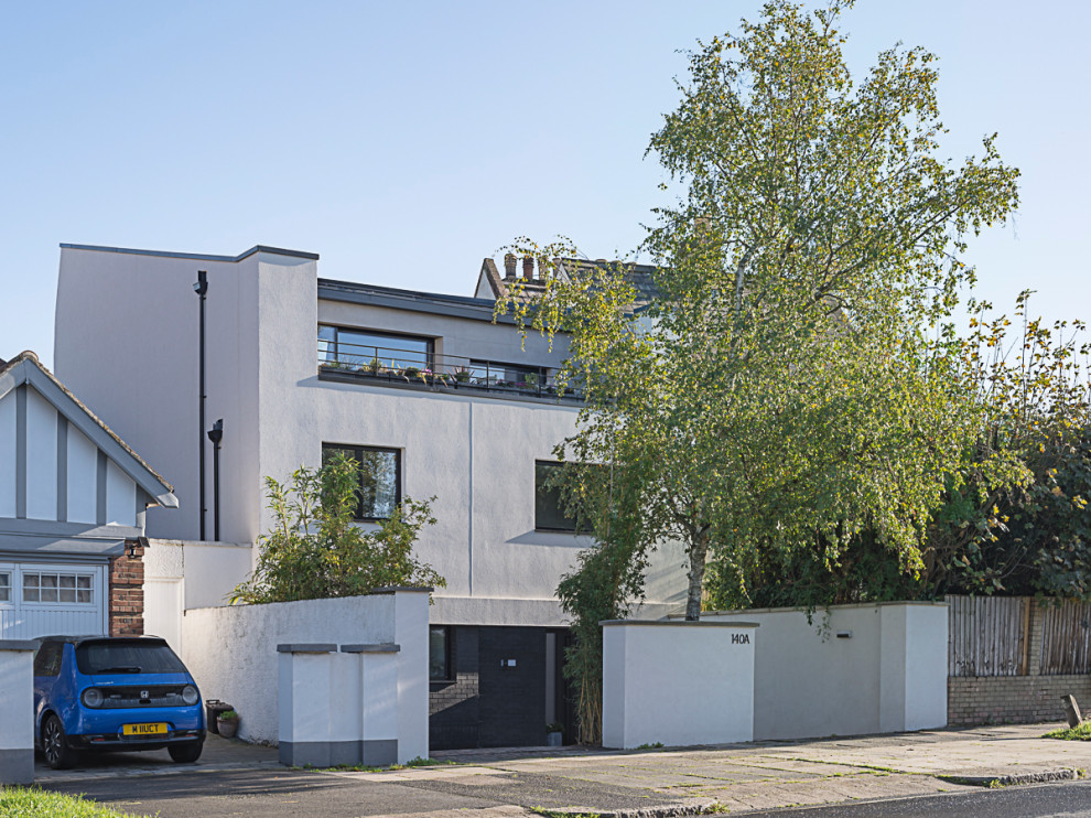 Imagen de fachada de casa blanca retro grande de tres plantas con revestimiento de estuco