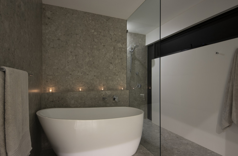 Modelo de cuarto de baño principal contemporáneo de tamaño medio con bañera exenta, ducha abierta, baldosas y/o azulejos grises, baldosas y/o azulejos de porcelana, paredes grises, suelo de baldosas de porcelana, suelo gris y ducha abierta