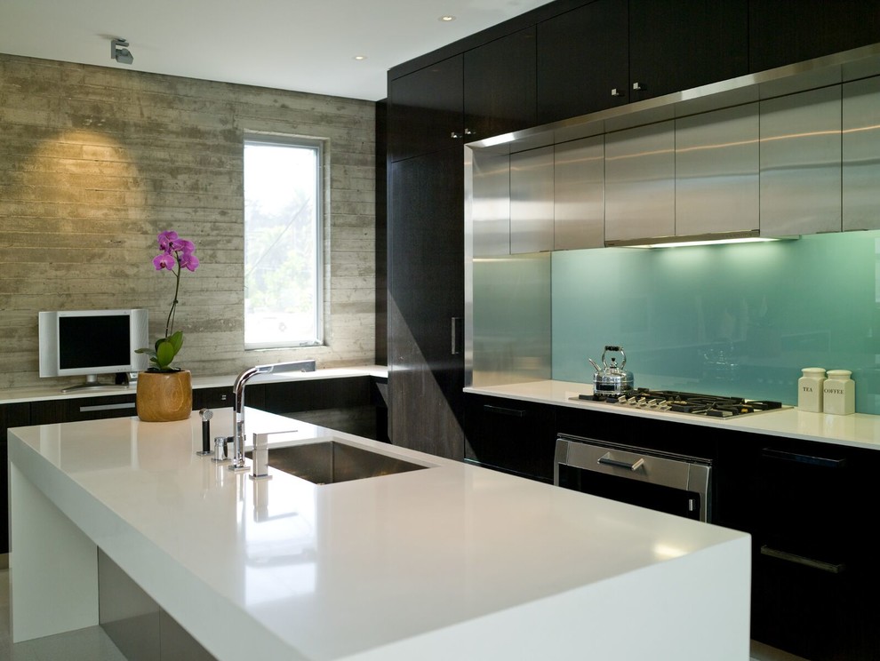 Design ideas for a large contemporary l-shaped kitchen in Los Angeles with an undermount sink, flat-panel cabinets, black cabinets, quartz benchtops, green splashback, glass sheet splashback, stainless steel appliances and with island.