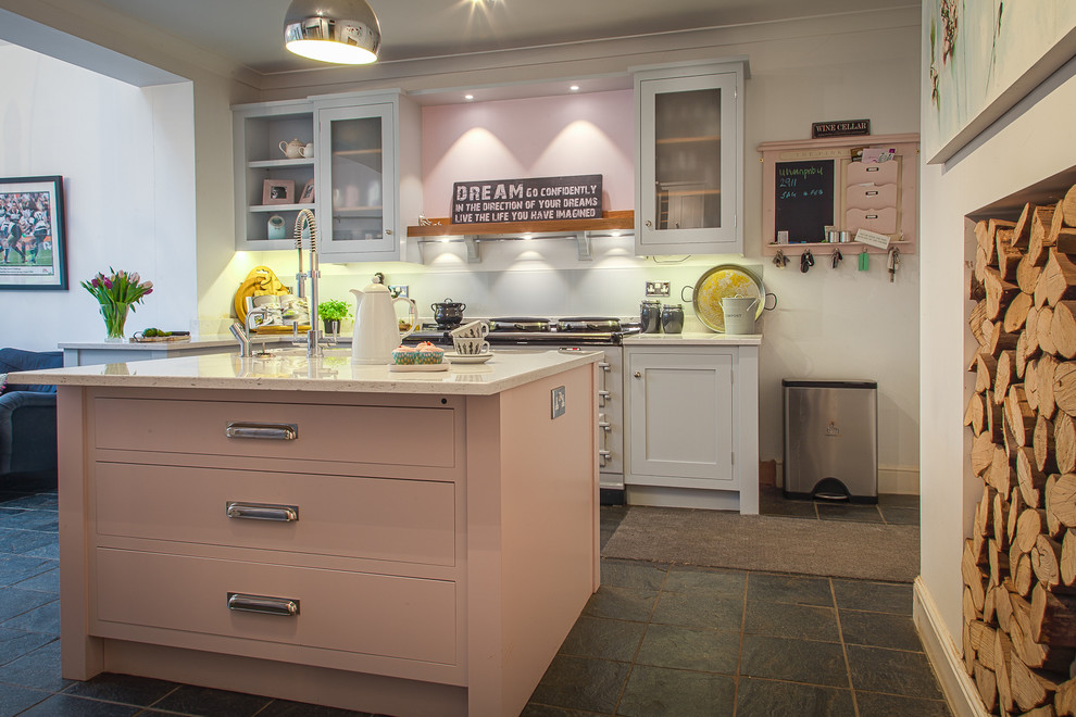 Photo of a mid-sized country l-shaped eat-in kitchen in Hertfordshire with an undermount sink, shaker cabinets, grey cabinets, quartz benchtops, grey splashback, glass sheet splashback, stainless steel appliances, slate floors and with island.