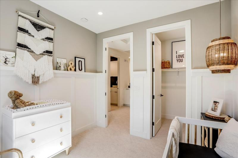 Стильный дизайн: нейтральная комната для малыша с ковровым покрытием, бежевым полом и панелями на стенах - последний тренд