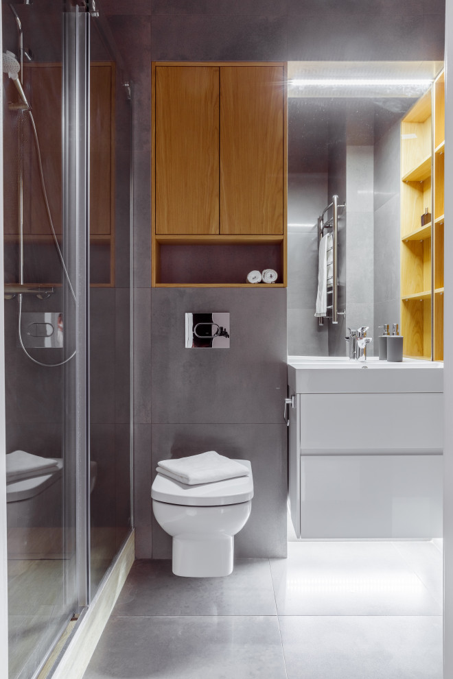 Inspiration for a mid-sized contemporary 3/4 bathroom in Other with flat-panel cabinets, white cabinets, an alcove shower, a wall-mount toilet, gray tile, porcelain tile, porcelain floors, grey floor, white benchtops, a single vanity and a floating vanity.