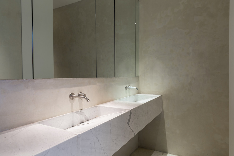 This is an example of a mid-sized contemporary 3/4 bathroom in New York with white cabinets, a double shower, white tile, stone slab, beige walls, marble floors and marble benchtops.