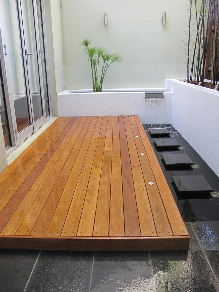 Design ideas for an asian courtyard garden in Sydney with a water feature and decking.
