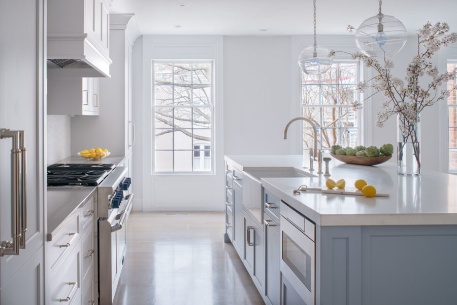 Large transitional single-wall laminate floor and beige floor eat-in kitchen photo in DC Metro with a farmhouse sink, flat-panel cabinets, blue cabinets, quartz countertops, white backsplash, mosaic tile backsplash, stainless steel appliances, an island and gray countertops