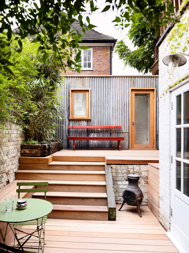 Inspiration for a mid-sized contemporary backyard garden in London with a container garden and decking.
