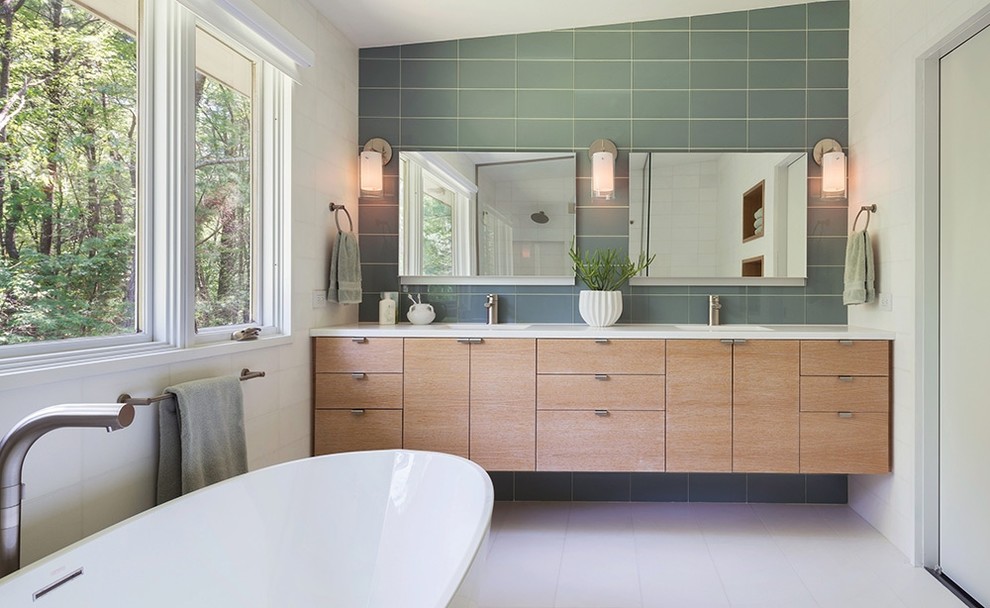 Photo of a mid-sized midcentury master bathroom in Los Angeles with an integrated sink, flat-panel cabinets, light wood cabinets, a freestanding tub, gray tile and white walls.