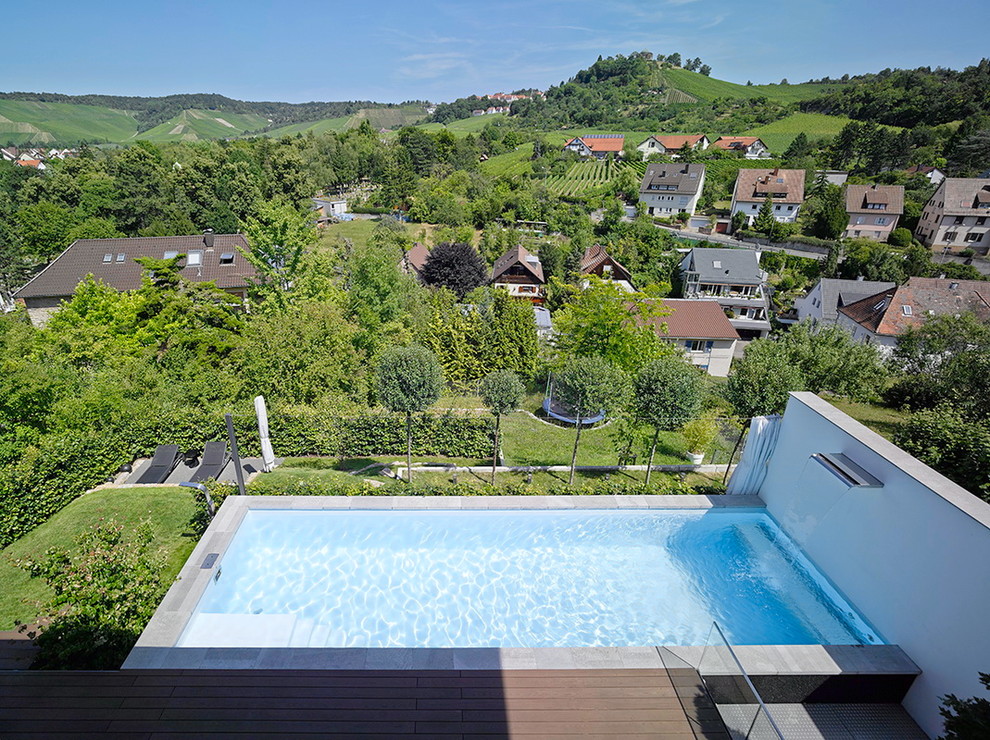 Inspiration for a mid-sized contemporary side yard rectangular lap pool in Stuttgart with a water feature.