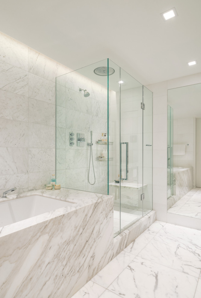 Photo of a contemporary bathroom in New York with an undermount tub, a corner shower, white tile and white floor.