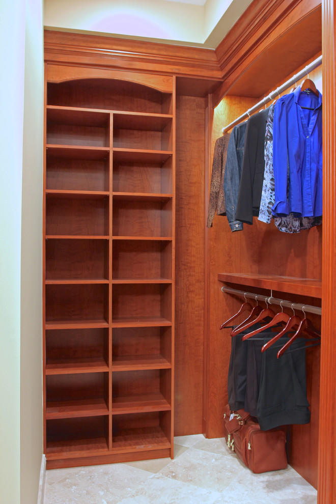 Photo of a large traditional walk-in wardrobe in Chicago with raised-panel cabinets, medium wood cabinets and travertine floors.
