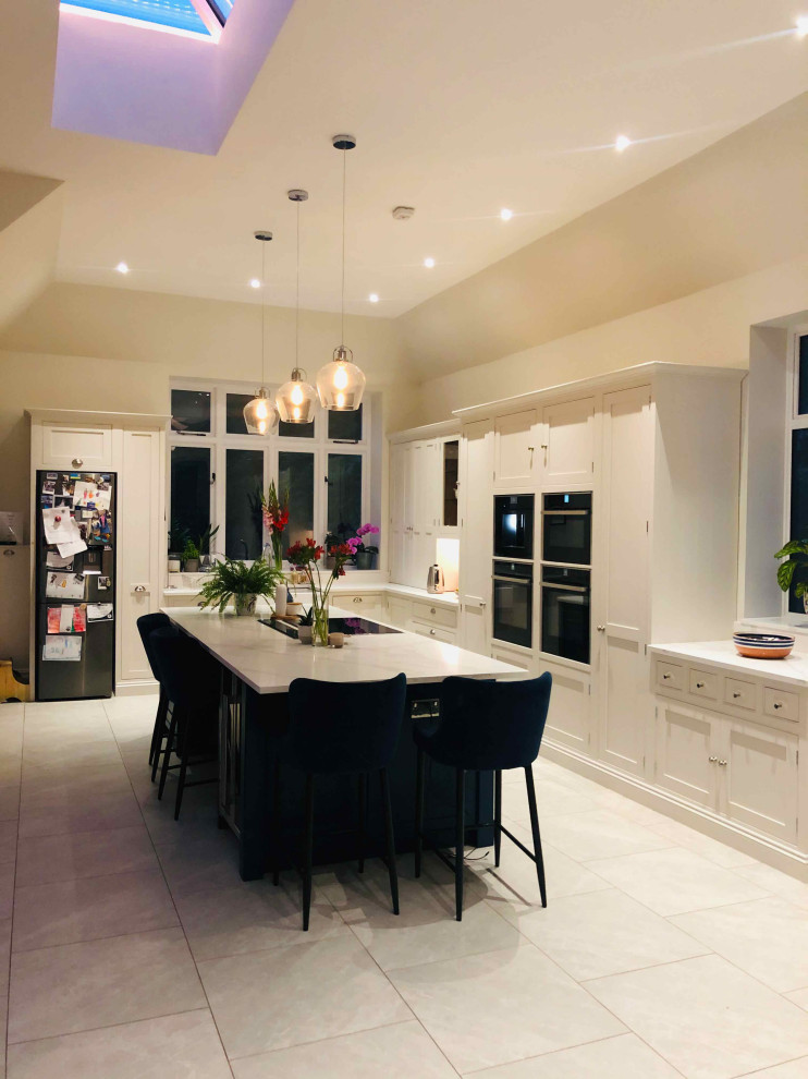 Design ideas for a large contemporary l-shaped open plan kitchen in Surrey with beaded inset cabinets, beige cabinets, quartzite benchtops and with island.