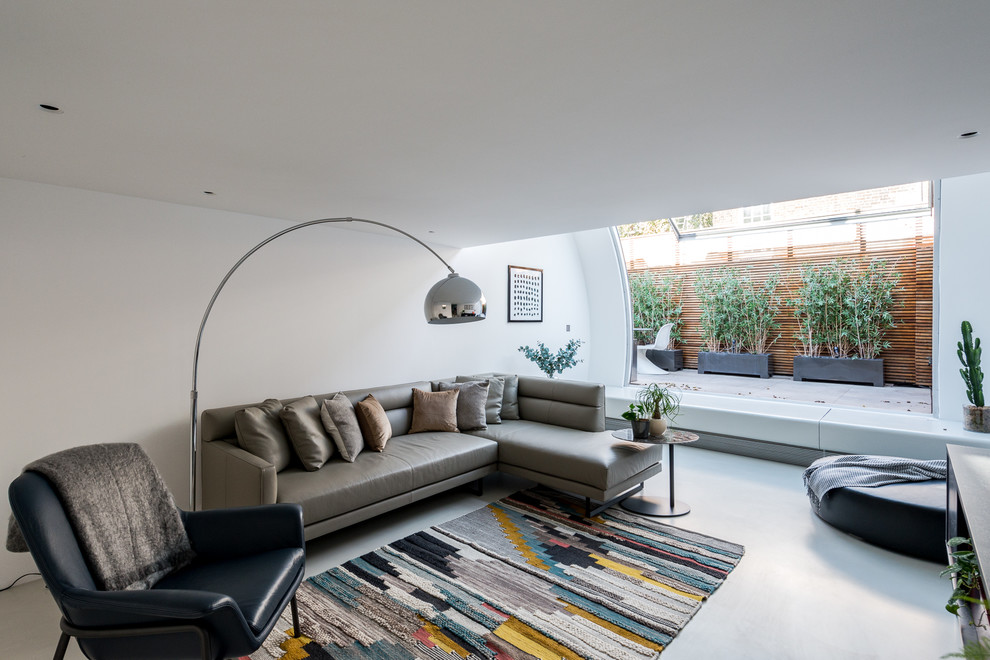 This is an example of a mid-sized modern living room in London with white walls, linoleum floors and grey floor.