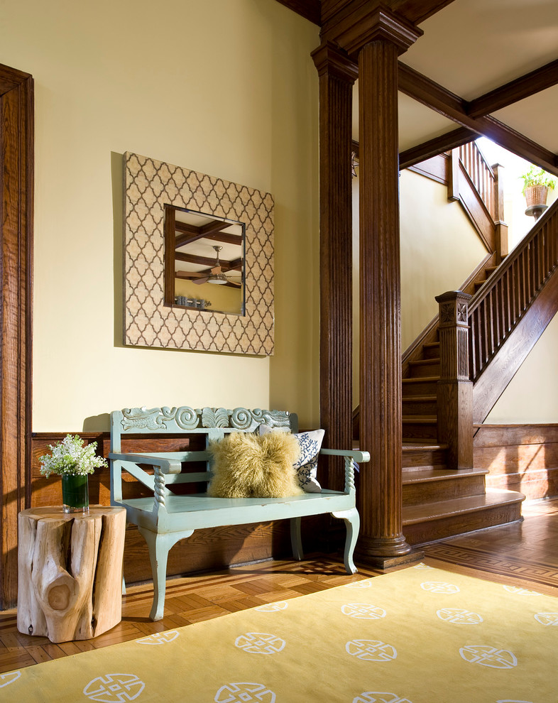 This is an example of a large traditional hallway in New York with yellow walls, light hardwood floors and brown floor.