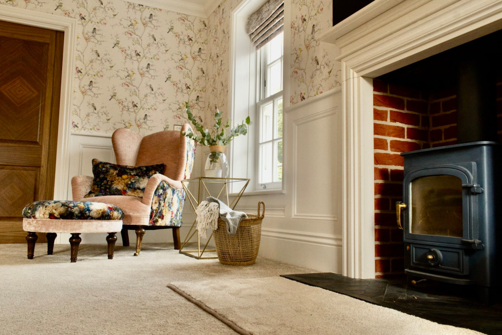 Inspiration for a large classic formal and grey and pink enclosed living room feature wall in Essex with pink walls, carpet, a wood burning stove, a stone fireplace surround, a wall mounted tv, beige floors, panelled walls and a feature wall.