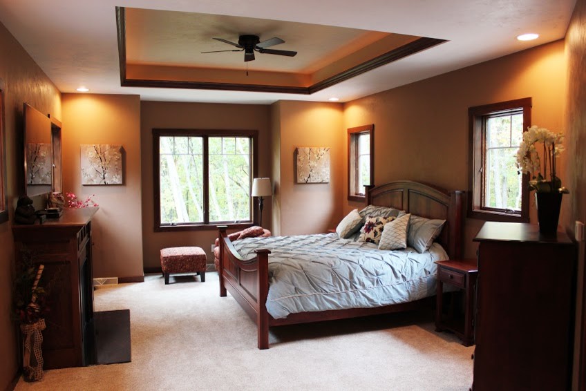 Mid-sized master carpeted bedroom photo with a standard fireplace and a wood fireplace surround