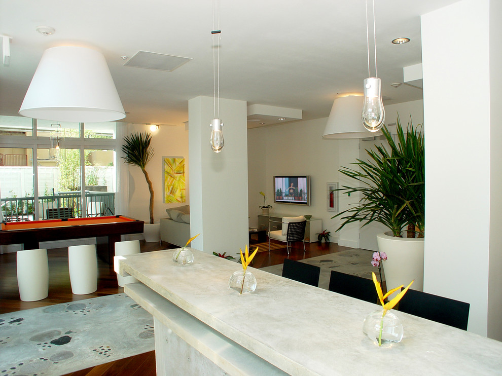 This is an example of a large contemporary single-wall seated home bar in Miami with open cabinets, grey cabinets, concrete benchtops and concrete floors.