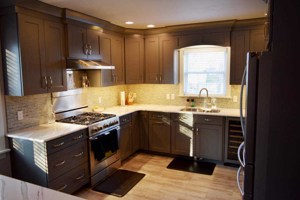 Transitional u-shaped kitchen photo with an undermount sink, shaker cabinets, gray cabinets, quartz countertops and stainless steel appliances