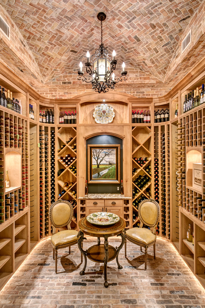 Mediterranean wine cellar in Houston with brick floors and storage racks.