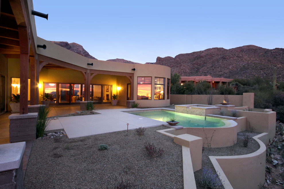 This is an example of an expansive mediterranean front yard pool in Phoenix with concrete slab.