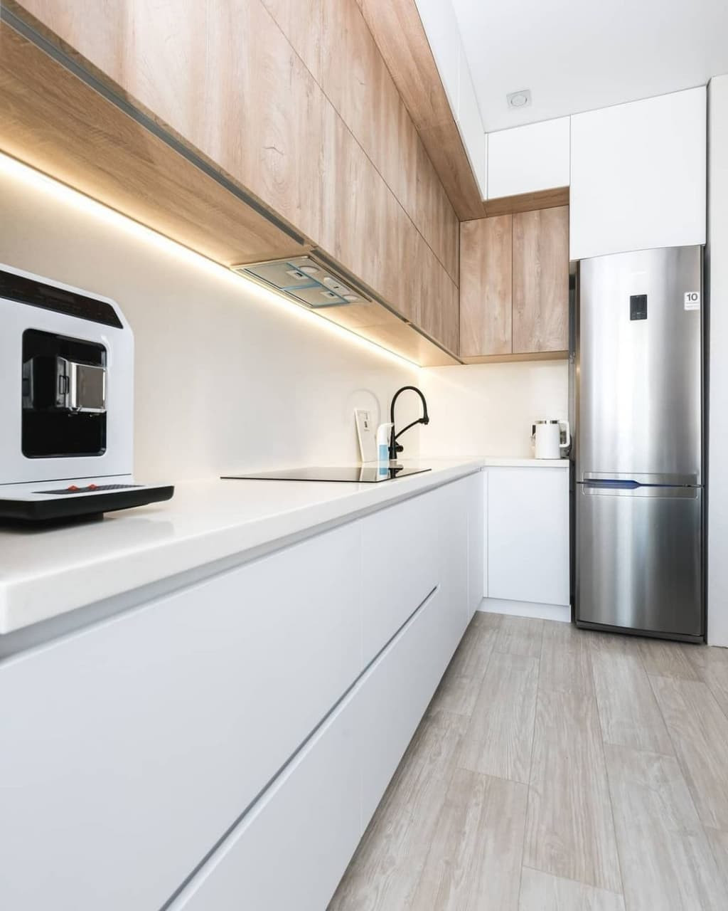 Белая угловая кухня со стеклянной витриной и бутылочницей