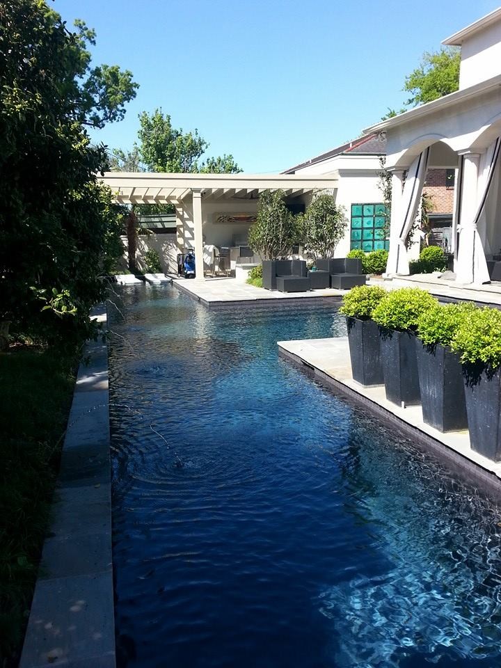Inspiration for a mid-sized contemporary backyard rectangular lap pool in New Orleans with natural stone pavers.