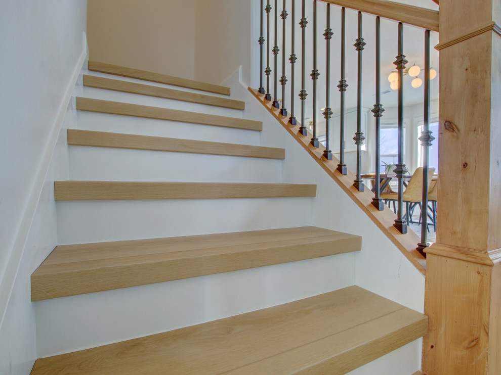 Ejemplo de escalera recta retro de tamaño medio con escalones de madera, contrahuellas de hormigón y barandilla de madera