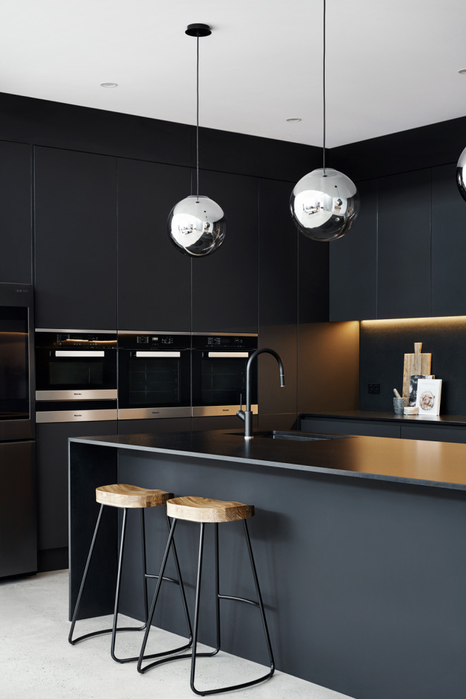 Inspiration for a large contemporary galley kitchen pantry in Sydney with flat-panel cabinets, black cabinets, quartz benchtops, black splashback, stone slab splashback, stainless steel appliances, concrete floors, no island, grey floor and black benchtop.