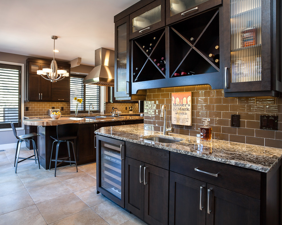 Photo of an expansive arts and crafts u-shaped open plan kitchen in Denver with an undermount sink, shaker cabinets, dark wood cabinets, granite benchtops, brown splashback, glass tile splashback, stainless steel appliances, ceramic floors and with island.