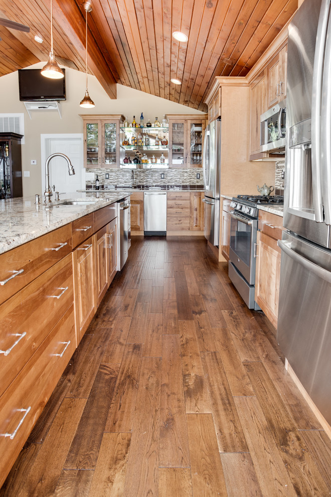 Inspiration for a large rustic kitchen remodel in DC Metro with an undermount sink, raised-panel cabinets, granite countertops, glass tile backsplash, stainless steel appliances and an island