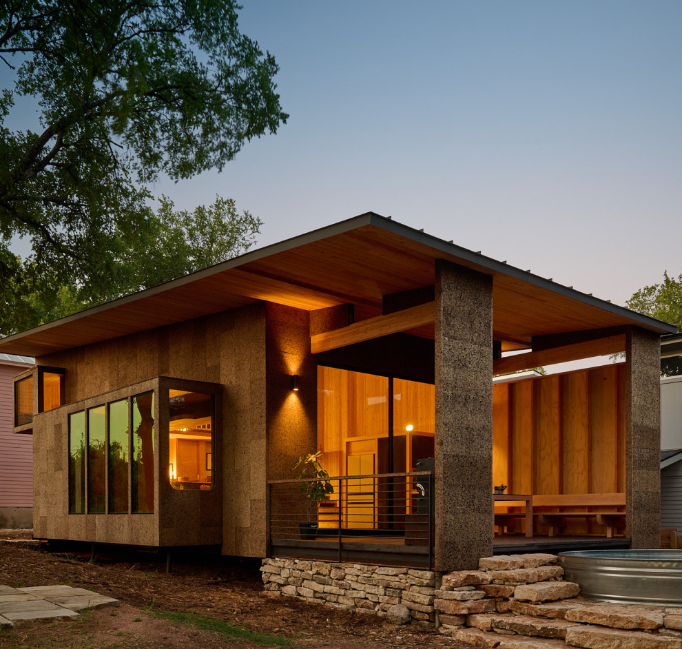 Photo of a mid-sized modern two-storey brown house exterior in Austin with a shed roof and a metal roof.