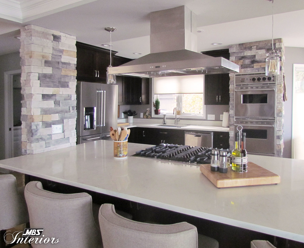 Eat-in kitchen - large transitional l-shaped light wood floor eat-in kitchen idea with an undermount sink, recessed-panel cabinets, dark wood cabinets, quartz countertops, stainless steel appliances and an island