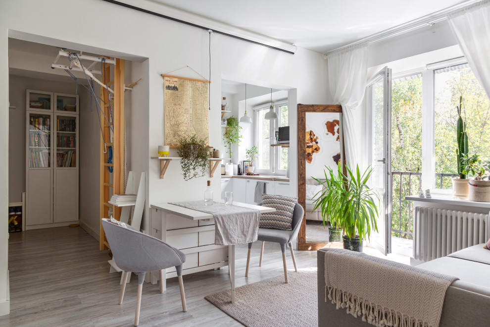 Inspiration for a scandinavian dining room in London with white walls and grey floor.