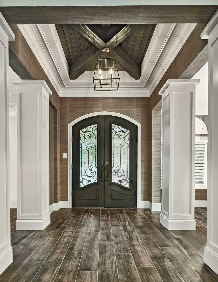 Traditional foyer in Dallas with brown walls, a double front door, a black front door and brown floor.