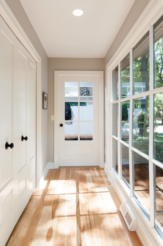 Entry hall - mid-sized transitional light wood floor entry hall idea in Detroit with gray walls