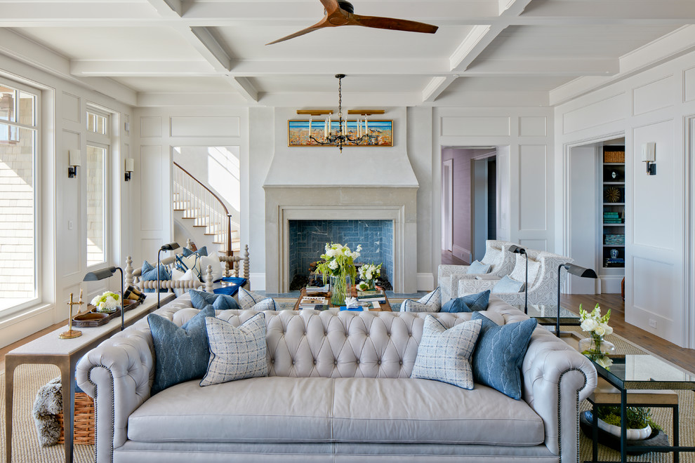 Design ideas for a large beach style living room in Charleston with white walls, medium hardwood floors, a standard fireplace and a stone fireplace surround.