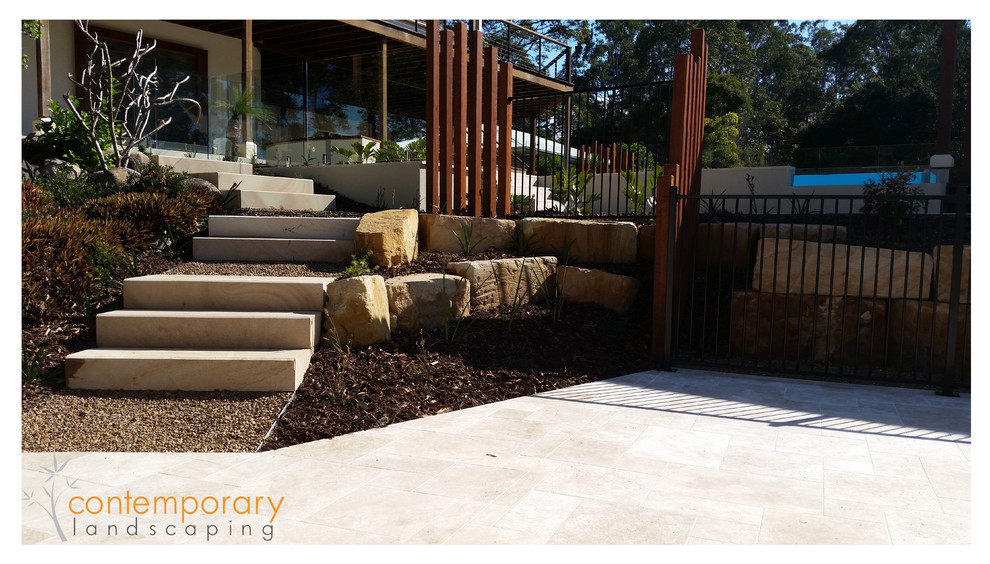 Design ideas for a contemporary backyard round natural pool in Sunshine Coast with decking.