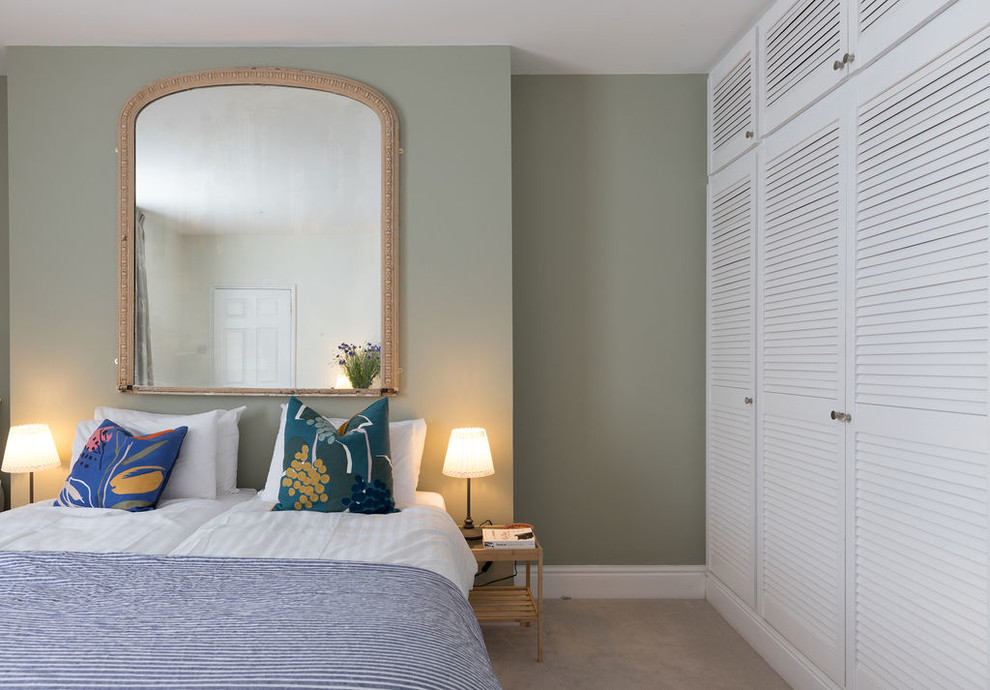 Inspiration for a mid-sized transitional guest bedroom in Sussex with green walls, carpet and beige floor.