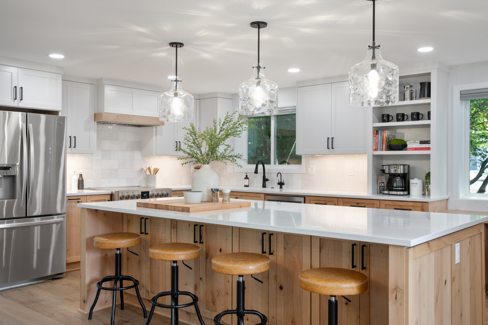 Design ideas for an expansive modern u-shaped eat-in kitchen in Portland with a drop-in sink, shaker cabinets, white cabinets, quartz benchtops, white splashback, ceramic splashback, stainless steel appliances, vinyl floors, with island, beige floor and white benchtop.