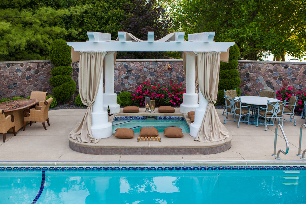Inspiration for a large traditional backyard rectangular lap pool in Other with a hot tub and concrete slab.
