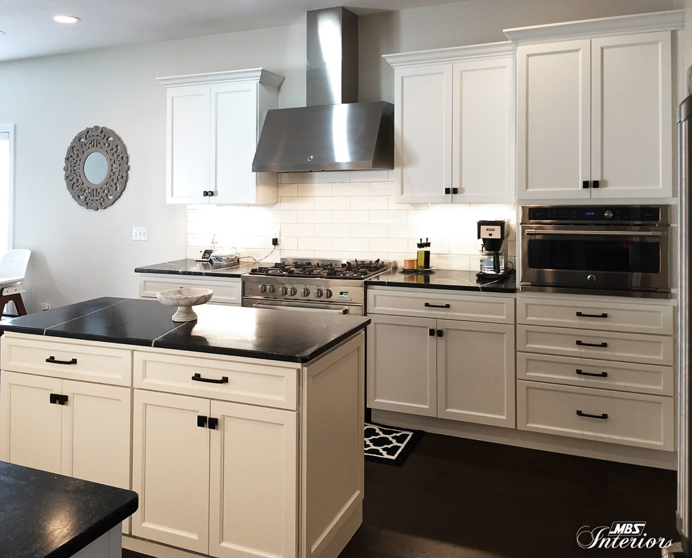 Inspiration for a mid-sized transitional u-shaped dark wood floor and brown floor eat-in kitchen remodel with an undermount sink, recessed-panel cabinets, white cabinets, soapstone countertops, white backsplash, subway tile backsplash, stainless steel appliances and an island