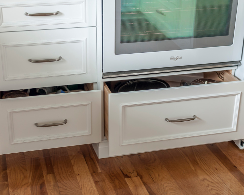 Example of a mid-sized transitional medium tone wood floor eat-in kitchen design in Denver with a single-bowl sink, flat-panel cabinets, yellow cabinets, quartz countertops, blue backsplash, glass tile backsplash, white appliances and an island