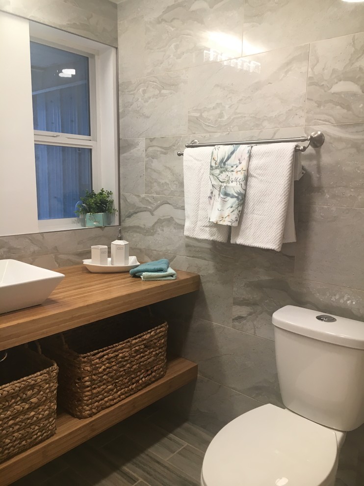 Design ideas for a mid-sized eclectic 3/4 bathroom in Calgary with open cabinets, light wood cabinets, an alcove shower, a one-piece toilet, green tile, ceramic tile, green walls, ceramic floors, a vessel sink, grey floor and a sliding shower screen.