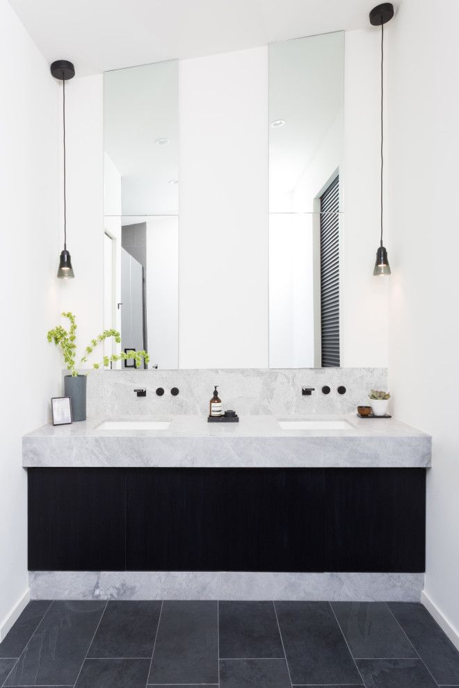 This is an example of a mid-sized modern master wet room bathroom in Los Angeles with flat-panel cabinets, black cabinets, a freestanding tub, a one-piece toilet, white tile, white walls, slate floors, an undermount sink, marble benchtops, grey floor, a hinged shower door, grey benchtops, a shower seat, a double vanity, a built-in vanity and vaulted.
