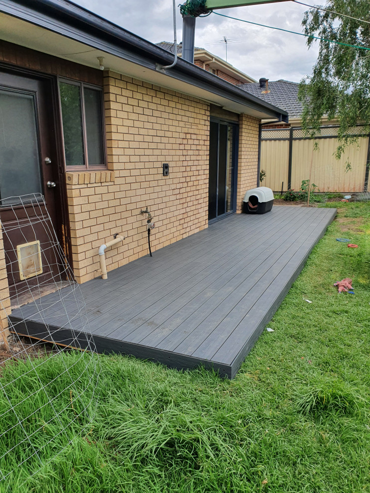 Inspiration for a small modern backyard and ground level deck in Melbourne with with privacy feature, a pergola and wood railing.