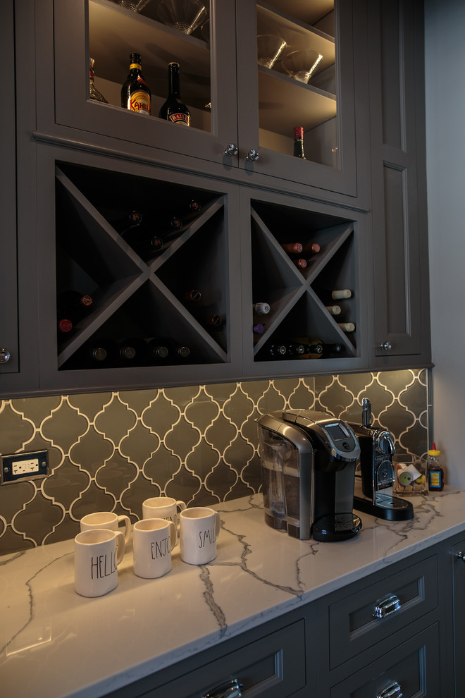Inspiration for a large transitional single-wall home bar in Chicago with an undermount sink, shaker cabinets, grey cabinets, marble benchtops, grey splashback, glass tile splashback and dark hardwood floors.