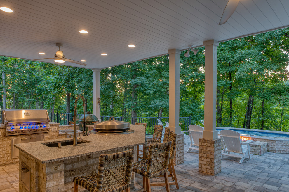 Large transitional backyard concrete paver patio kitchen photo in Other with a roof extension
