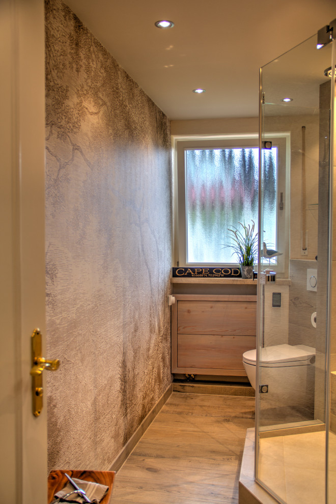 Photo of a small traditional 3/4 bathroom in Munich with flat-panel cabinets, beige cabinets, a curbless shower, a two-piece toilet, beige tile, wood-look tile, beige walls, wood-look tile, an integrated sink, glass benchtops, brown floor, a hinged shower door, white benchtops, a shower seat, a single vanity, a floating vanity, recessed and wallpaper.